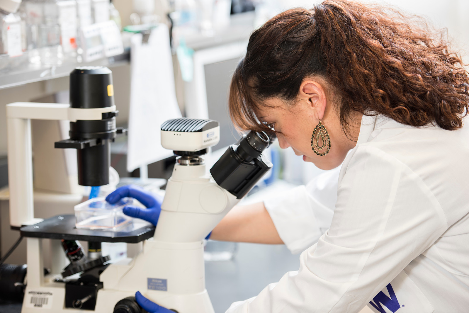 Photo of researcher using a microscope.   Credit: University of Washington