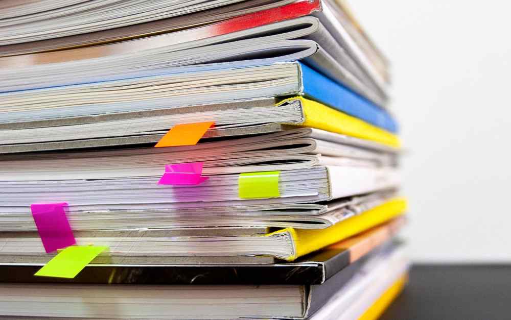 Colorful image of multiple open journals. Photo by Bernd Klutsch on Unsplash.